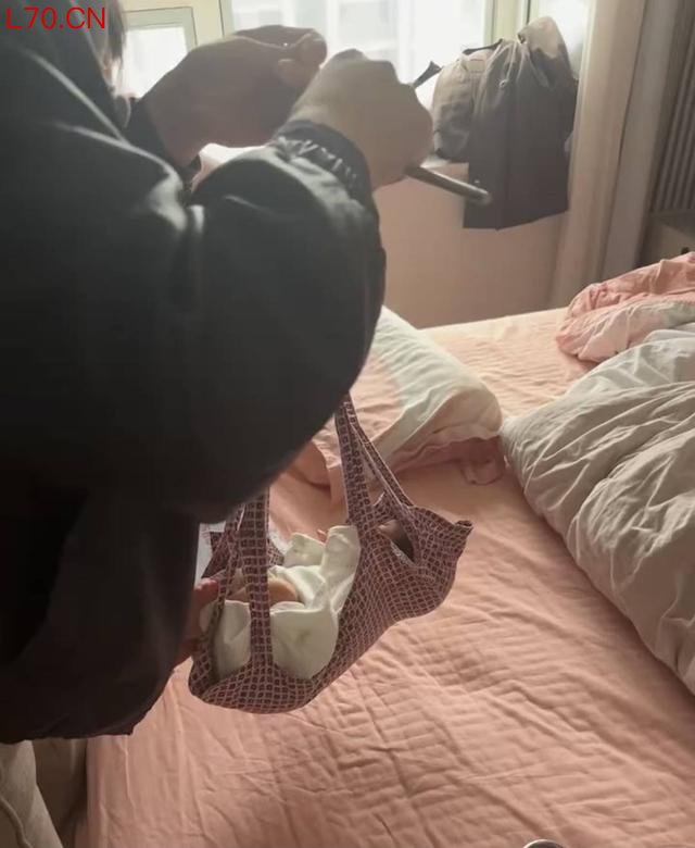 工作人员用老式杆秤为婴儿称重（视频截图）